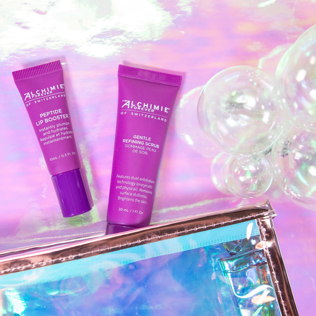 Two purple skincare products from Alchimie Forever on a reflective surface with a colorful, iridescent background.