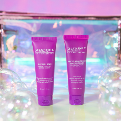 Two purple Alchimie Forever skincare products on a colorful, reflective background.