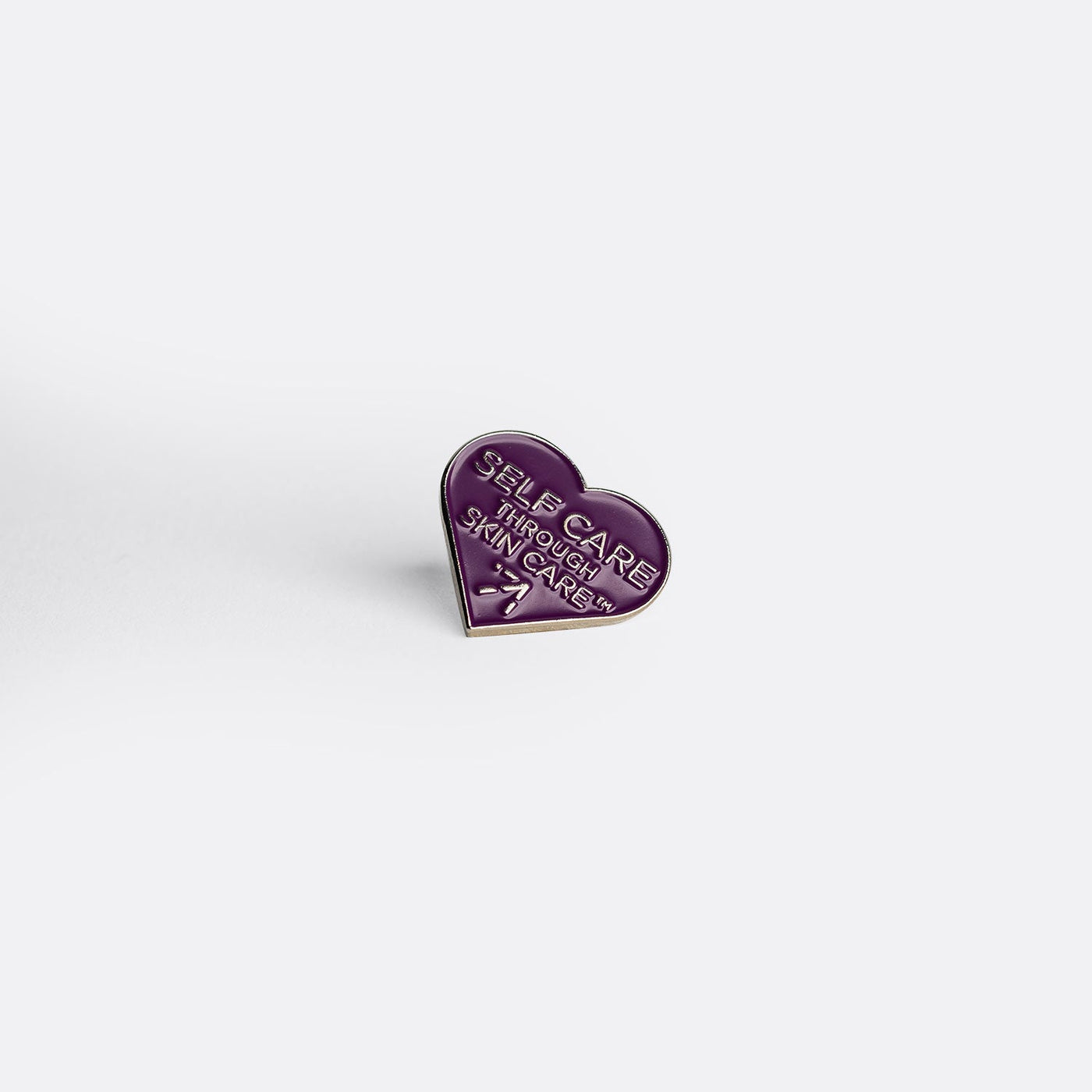 Alchimie Forever's brand new "self care through skin care" purple heart pin.